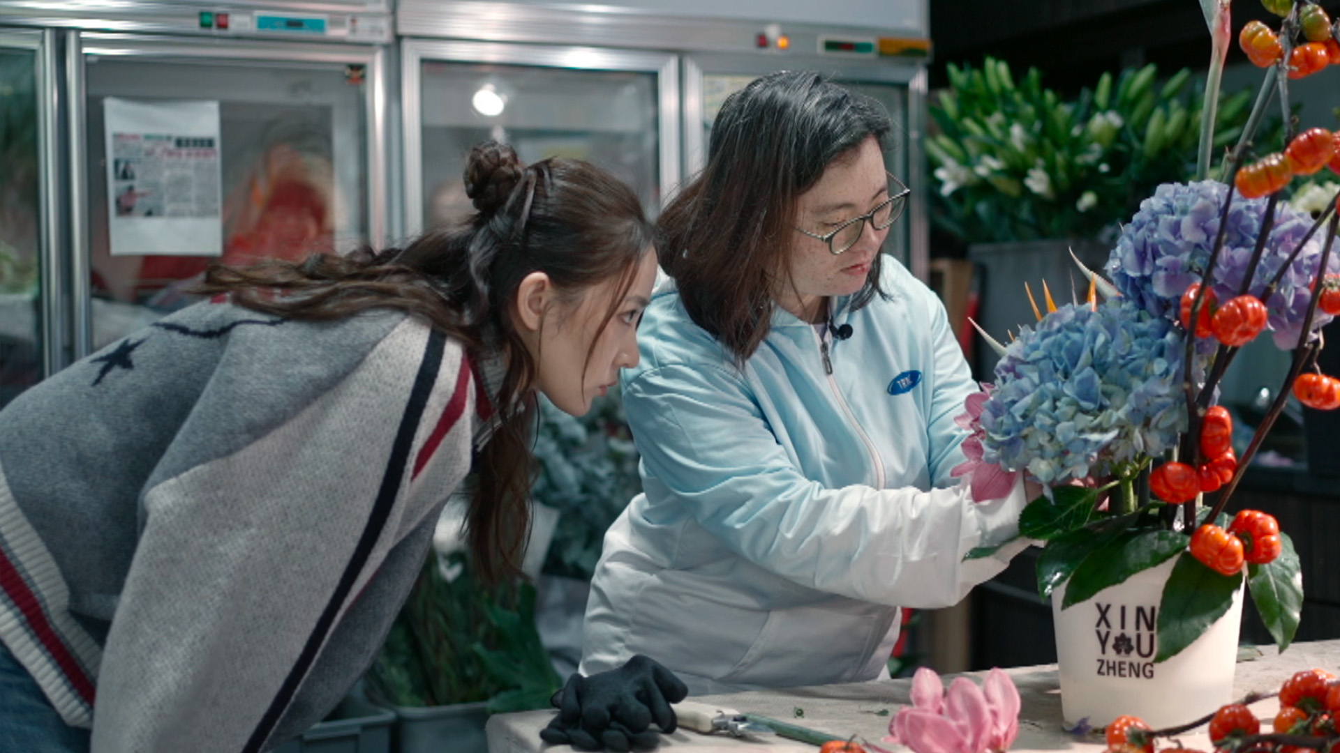 Chingyin demonstrates to Sofiee how to arrange flowers correctly.